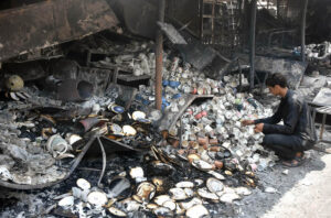 A stall holder examine the burnt remains of his stall which burnt due to yesterday’s fire at the H-9 Weekly Bazaar
