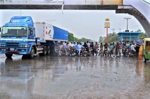 People standing under the bus stop shed at Expressway to take shelter during rain that experienced the Federal Capital.