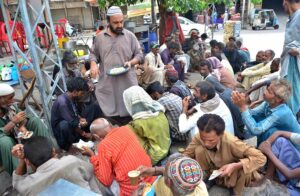 Volunteer distributing breakfast among the deserving people at Fort Road.