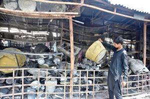 A stall holder examine the burnt remains of his stall which burnt due to yesterday’s fire at the H-9 Weekly Bazaar