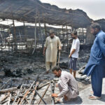 A stall holder examine the burnt remains of his stall which burnt due to yesterday’s fire at the H-9 Weekly Bazaar