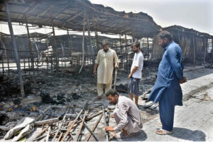 A stall holder examine the burnt remains of his stall which burnt due to yesterday’s fire at the H-9 Weekly Bazaar