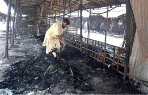 A stall holder examine the burnt remains of his stall which burnt due to yesterday’s fire at the H-9 Weekly Bazaar