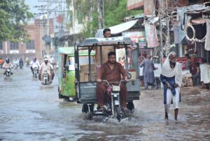 Vehicles passing through stagnant rain water accumulated at Iqbal Stadium Road.