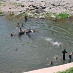 Youngsters jumping and bathing in a water pond near Rawal Dam to get some relief from hot weather in the Federal Capital