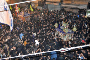 Volunteer serving drinks to the mourners at Sabeel during Muharram-ul-Harram outside Qadamgah.