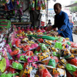 Vendor displaying Children's plastic toys to attract the customers at roadside in the city