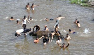 Youngsters jumping and bathing in nullah korang to get relief from hot weather in Federal Capital