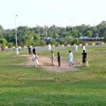 Boys playing cricket on the Faizabad-Islamabad Express Highway