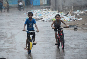 Children enjoy riding bicycles on a rainy day