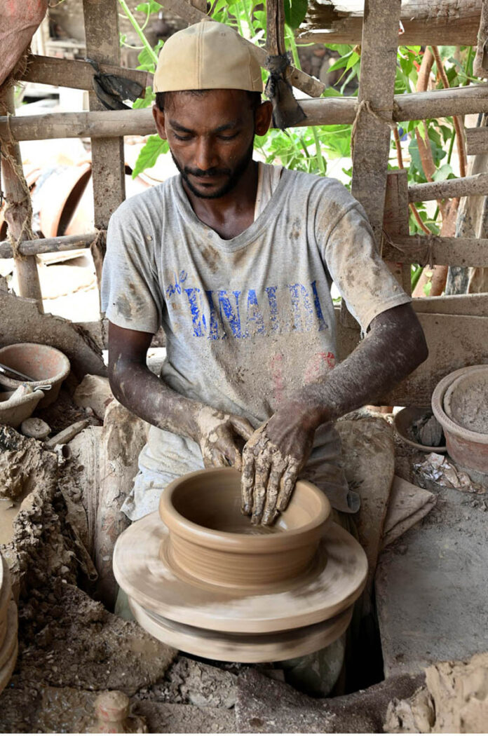 An artisan busy prepaying clay-made stuff at his work place in Kumharpara at Jamshoro road