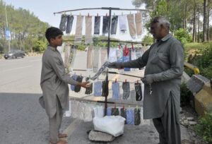 A customer purchases gloves from a local vendor in the Federal Capital