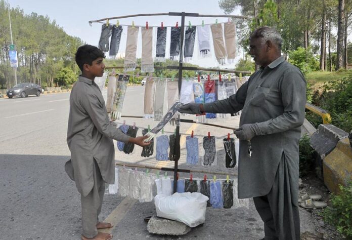 A customer purchases gloves from a local vendor in the Federal Capital