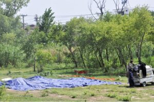 Caterers spread tents under the sunlight on a roadside green belt to dry after last night's rain