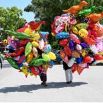 Vendors selling colorful balloons to attract customers while shuttling on road at G-9 Markaz in the Federal Capital