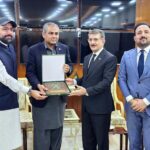 Interior Minister Mohsin Naqvi and Federal Minister for Overseas Pakistanis and Religious Affairs Chaudhry Salik Hussain presenting a souvenir to Ambassador of Iraq Hamid Abbas Lafta