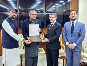 Interior Minister Mohsin Naqvi and Federal Minister for Overseas Pakistanis and Religious Affairs Chaudhry Salik Hussain presenting a souvenir to Ambassador of Iraq Hamid Abbas Lafta