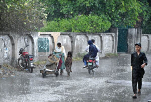 People on the way to their destination at Tarlai during rain that experienced in the Federal Capital.