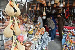 A family selecting and purchasing decoration items and other stuff from vendor at Bari Imam shrine in the Federal Capital
