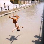 Youngster diving into the canal to get some relief from extreme hot weather in the city