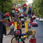 A vendor displaying dolls on his bicycle to attract customers at Roadside