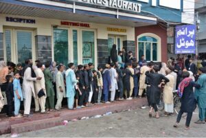 People are standing in a queue to receive free food being distributed by volunteers during Holy month of Muharram ul Harram.