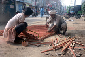 Carpenters preparing bamboo ladder outside their shop in a local market