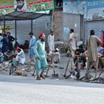 Labourers alongwith their tools sitting on roadside waiting for clients to be hired for work during morning time at Khanna Pul