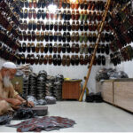 A cobbler preparing traditional shoes (Peshawari Chappal) to the customers at his workplace