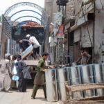 Laborers are loading iron sheets on truck at Loha Market