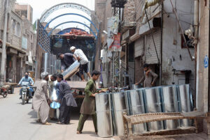Laborers are loading iron sheets on truck at Loha Market