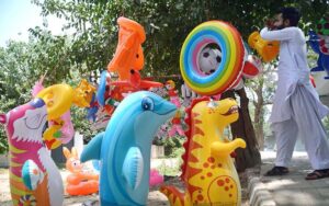 A vendor is displaying colorful toys for children to attract the customers in front of Cantt Railway Station.