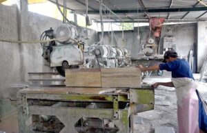 A worker is busy cutting and polishing marble at a local factory in the Federal Capital.