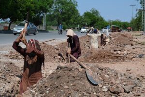 Labourers busy in construction work of flyover at under construction 10th Avenue during development work in Federal Capital
