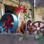 A worker prepares fan blades for room coolers at his workplace