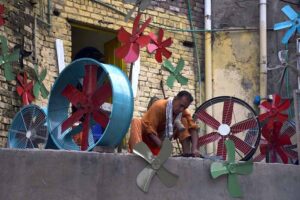 A worker prepares fan blades for room coolers at his workplace