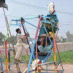 Children enjoy the swings at roadside
