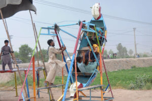 Children enjoy the swings at roadside