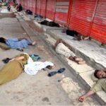 A large number of labourers sleeping in front of shops at Furniture Market