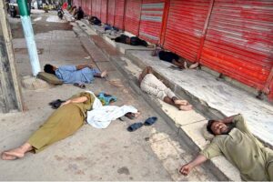 A large number of labourers sleeping in front of shops at Furniture Market