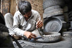 A man busy in making rubber tubs with scrap tires at his workplace near Dabgari area.
