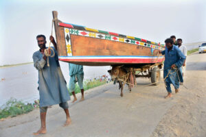 Fishermen transport their boat on a donkey cart through Jamshoro .
