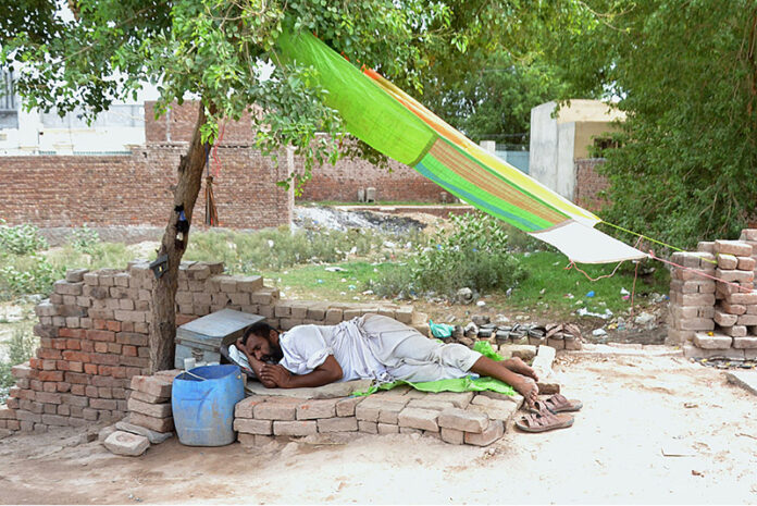 A cobbler takes a well-deserved nap after a day's work on Muzaffargarh Road
