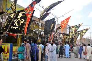 A worker is busy showering paint on the historical Tazia for the preparation of Youme-Ashura procession.