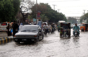 City streets transform into rivers as heavy rains inundate roads, challenging drivers to navigate through the storm in the city.