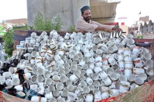 A vendor is busy displaying tea cups at roadside setup to attract the customers