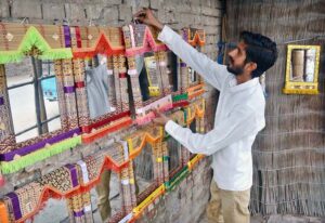 A vender is displaying fancy mirrors on a roadside wall to attract the customers.