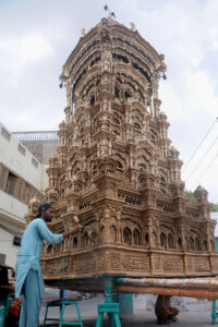 A worker is busy showering paint on the historical Tazia for the preparation of Youme-Ashura procession.