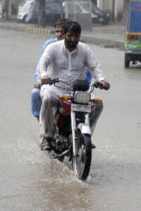 City streets transform into rivers as heavy rains inundate roads, challenging drivers to navigate through the storm in the city.