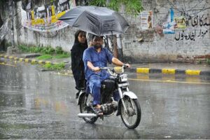 A woman holding an umbrella to protect from rain while riding on motorcycle in the Provincial Capital